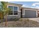 Charming home exterior featuring stone accents, a two-car garage, and manicured landscaping at 18507 E Camila Dr, Gold Canyon, AZ 85118