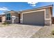 A home exterior featuring stone accents, a gray garage door and brick paved driveway at 18507 E Camila Dr, Gold Canyon, AZ 85118