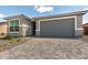 A home exterior featuring stone accents, a gray garage door and brick paved driveway at 18507 E Camila Dr, Gold Canyon, AZ 85118