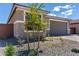 View of the gray stone exterior elevation featuring a well maintained yard and gray garage door at 18507 E Camila Dr, Gold Canyon, AZ 85118