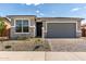 Charming single-story home featuring stone accents, a gray garage door, and a well-manicured front yard at 18507 E Camila Dr, Gold Canyon, AZ 85118