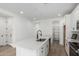 Bright kitchen featuring white cabinets, stainless steel appliances, a pantry, and an island with a sink at 18507 E Camila Dr, Gold Canyon, AZ 85118