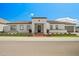 Stunning single-story home featuring a white exterior, tile roof, brick accents, and a well-manicured front yard at 17448 W Carlisle Dr, Surprise, AZ 85388