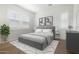 Bright main bedroom featuring a gray upholstered bedframe, light walls, and hardwood floors at 17448 W Carlisle Dr, Surprise, AZ 85388