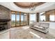 Bright living room with fireplace, a tan sofa and views of the outdoors at 11070 E Rolling Rock Dr, Scottsdale, AZ 85262