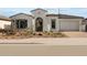 Charming single-story home featuring a white exterior, tile roof, arched entryway, and a meticulously landscaped front yard at 4315 S 123Rd Ave, Avondale, AZ 85323