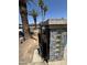 View of a black metal front gate with stone and glass block pillar on a sunny day with palm trees at 5007 W Weldon Ave, Phoenix, AZ 85031