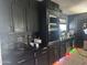 Modern kitchen featuring black cabinetry, stainless steel appliances, and eye-catching mosaic backsplash at 5007 W Weldon Ave, Phoenix, AZ 85031
