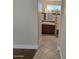 Hallway view of bathroom featuring a modern vanity, tiled floor and a window at 19595 N Sunburst Way, Surprise, AZ 85374