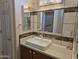 Bathroom vanity with a large mirror, stylish lighting, and modern fixtures at 19595 N Sunburst Way, Surprise, AZ 85374