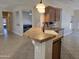 Kitchen sink and counter area with bar top overlooking living areas with tile flooring at 19595 N Sunburst Way, Surprise, AZ 85374