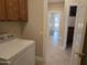 Bright laundry room with wood cabinets and white appliances, conveniently located near living areas at 19595 N Sunburst Way, Surprise, AZ 85374