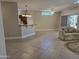 Open-concept living area featuring a breakfast bar, ceiling fan, and sliding glass door to a lanai at 19595 N Sunburst Way, Surprise, AZ 85374