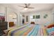 Bright bedroom with ceiling fan, large window, and ensuite bathroom with soaking tub at 1660 N 59Th St, Mesa, AZ 85205