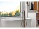 Elegant soaking tub with designer fixtures and a large window overlooking the natural landscape at 24724 N 119Th Pl, Scottsdale, AZ 85255