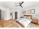 Sunlit bedroom with a wooden bed frame, hardwood floors, and ensuite bathroom access at 24724 N 119Th Pl, Scottsdale, AZ 85255
