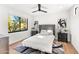Modern bedroom with a tufted headboard, stylish rug, and an abundance of natural light from the large window at 24724 N 119Th Pl, Scottsdale, AZ 85255