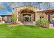 A beautiful home with a lush green lawn, desert landscaping, and a grand entrance at 24724 N 119Th Pl, Scottsdale, AZ 85255