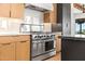 Close up of a stainless steel stove with light wood cabinets and white backsplash at 24724 N 119Th Pl, Scottsdale, AZ 85255