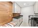 Well-organized laundry room with modern appliances, cabinets, and a stylish wood accent wall at 24724 N 119Th Pl, Scottsdale, AZ 85255