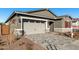 New home exterior features a two-car garage and red shutters at 16400 W Avenida Del Sol --, Surprise, AZ 85387