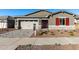 New home exterior with a red door and stone accents at 16400 W Avenida Del Sol --, Surprise, AZ 85387