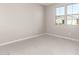 Bright bedroom with tile flooring and two windows at 40347 W Wade Dr, Maricopa, AZ 85138
