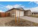 Exterior view showcasing the two-car garage, neutral tones, and low-maintenance landscaping with a stone driveway at 18812 E Elizar Dr, Gold Canyon, AZ 85118