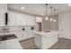 Modern white kitchen featuring an island with a sink, pendant lights, and white subway tile backsplash at 18812 E Elizar Dr, Gold Canyon, AZ 85118