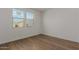 Light-filled bedroom with wood-look floors and window at 40461 W Wade Dr, Maricopa, AZ 85138
