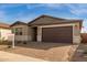 Modern one-story home with brown garage door at 40461 W Wade Dr, Maricopa, AZ 85138