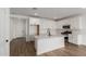 Modern kitchen with white cabinets, large island, and stainless steel appliances at 40461 W Wade Dr, Maricopa, AZ 85138