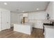 Modern kitchen with white cabinets, island, and stainless steel appliances at 40461 W Wade Dr, Maricopa, AZ 85138
