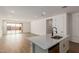 Open floor plan with kitchen island and living room with sliding door to backyard at 40461 W Wade Dr, Maricopa, AZ 85138