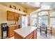 Kitchen with wood cabinets, island, white appliances, and breakfast nook at 6145 E Sierra Morena St, Mesa, AZ 85215