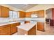 Kitchen with light wood cabinets, island, and white appliances at 6145 E Sierra Morena St, Mesa, AZ 85215