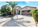 Front view of a house with a large palm tree and two-car garage at 29110 N 129Th Ave, Peoria, AZ 85383
