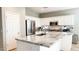 White kitchen with granite island, stainless steel appliances, and tile flooring at 29110 N 129Th Ave, Peoria, AZ 85383