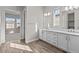 Stylish bathroom with dual sinks, white cabinets, and wood-look flooring at 12312 W Luxton Ln, Avondale, AZ 85323