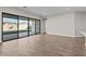 Spacious living room featuring wood-style flooring and large glass sliding doors to the backyard at 12312 W Luxton Ln, Avondale, AZ 85323