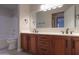Bathroom featuring dual sinks, wooden cabinets, and walk-in shower at 2119 N Lake Shore Dr, Casa Grande, AZ 85122