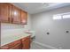 Laundry room with wooden cabinets, light countertop, and utility sink at 2119 N Lake Shore Dr, Casa Grande, AZ 85122