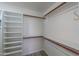 Bright walk-in closet featuring wood rods and white shelving units at 2119 N Lake Shore Dr, Casa Grande, AZ 85122