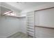 Walk-in closet with wood rods and white shelving units at 2119 N Lake Shore Dr, Casa Grande, AZ 85122
