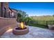 Relaxing backyard with a stone fire pit, pavers, and desert landscaping for outdoor entertainment at 10537 N Crestview Dr, Fountain Hills, AZ 85268