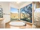 A bathtub sits below large windows with scenic views, offering a luxurious bathing experience at 10537 N Crestview Dr, Fountain Hills, AZ 85268