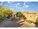 Stunning home featuring a circular stone facade, a paver driveway, and lush desert landscaping under a bright, cloudy sky at 10537 N Crestview Dr, Fountain Hills, AZ 85268