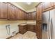 Large laundry room with lots of wooden cabinets and a stainless steel refrigerator at 10537 N Crestview Dr, Fountain Hills, AZ 85268