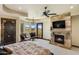 Spacious main bedroom features stone fireplace, chandelier, ceiling fan, and scenic outdoor views at 10537 N Crestview Dr, Fountain Hills, AZ 85268