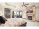 The main bedroom includes a stone fireplace, a mounted television, and patio access with stunning views at 10537 N Crestview Dr, Fountain Hills, AZ 85268